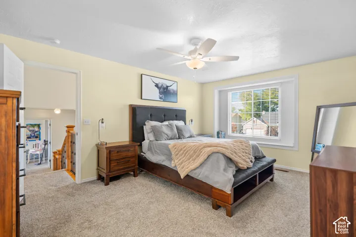 Carpeted flooring, ceiling fan, and window with blinds