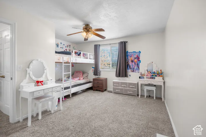 Wall-to-wall carpeting and a ceiling fan with integrated lighting