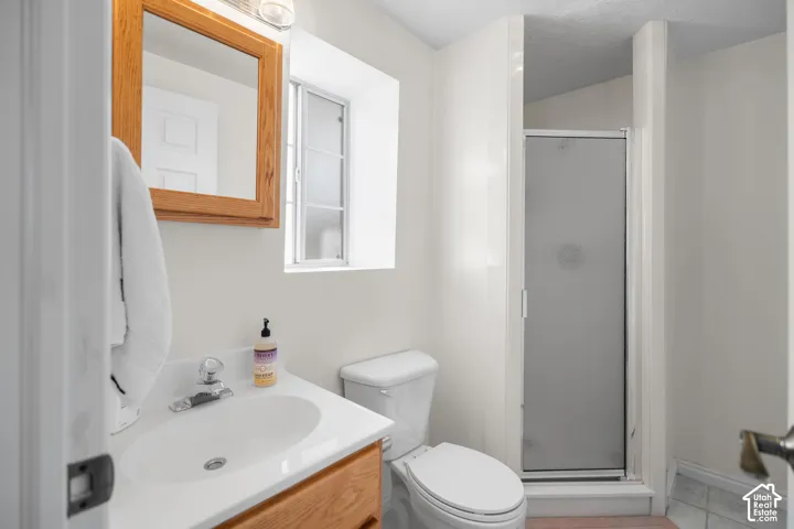 White vanity with integrated sink, wood-finish cabinetry, chrome faucet, and mirrored medicine cabinet