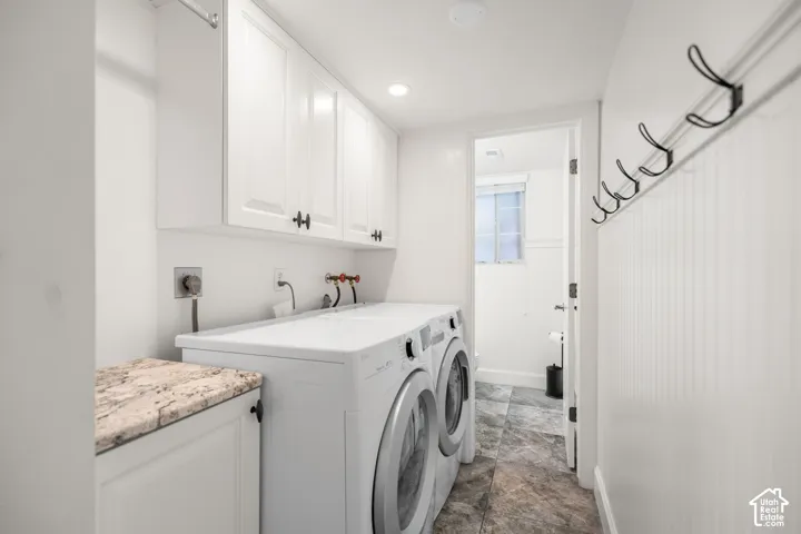 Laundry area featuring upper cabinetry, a granite-finish countertop, and tiled flooring