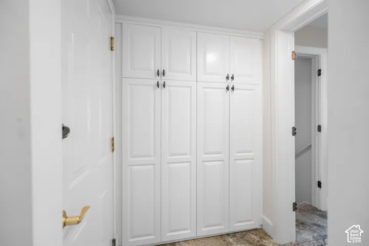 White built-in cabinetry with paneling, crown molding, and dark hardware