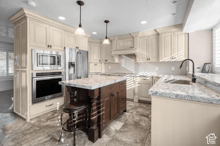 Kitchen featuring a central island with a contrasting wood base and stone countertop, stainless steel appliances, recessed lighting, and tile flooring