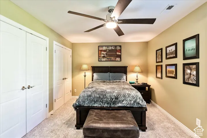 Recessed closet doors with brushed nickel hardware, ceiling fan with integrated lighting, textured carpeting, and light-toned wall finishes