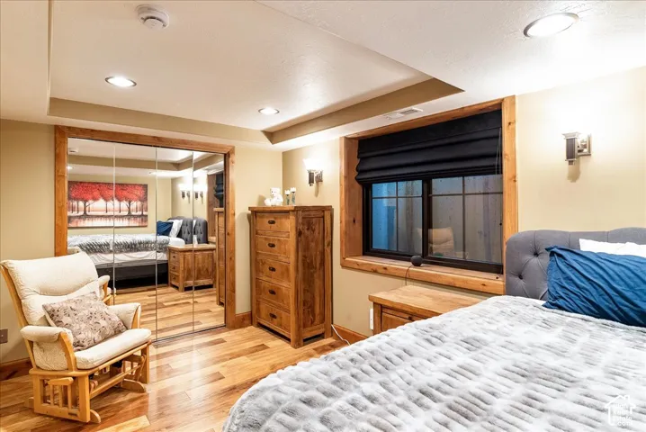 Wood-finish flooring, recessed lighting, and a window with a wood-trimmed frame