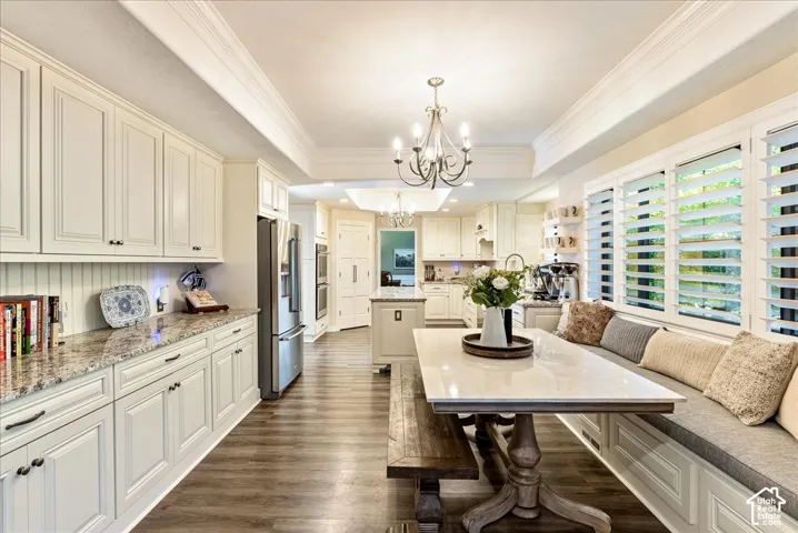 Kitchen featuring white cabinetry, wood-finish flooring, recessed lighting, and a breakfast nook with built-in seating