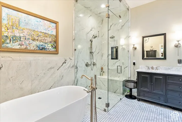Freestanding soaking tub, walk-in glass shower with built-in bench, dual shower heads, and an integrated niche