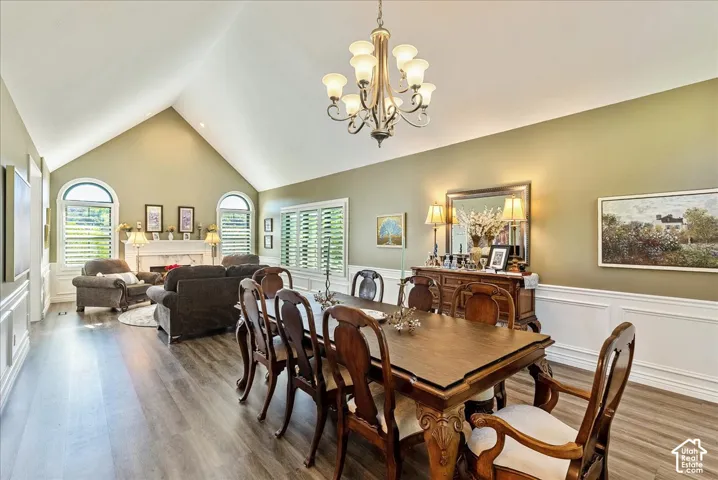 Vaulted ceilings, wood-finish flooring, and arched windows with plantation shutters