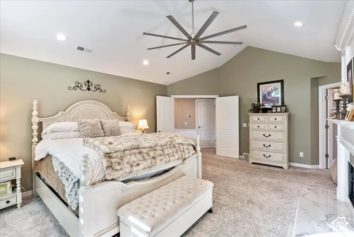 Vaulted ceiling with an installed ceiling fan, recessed lighting, and soft grey wall tones