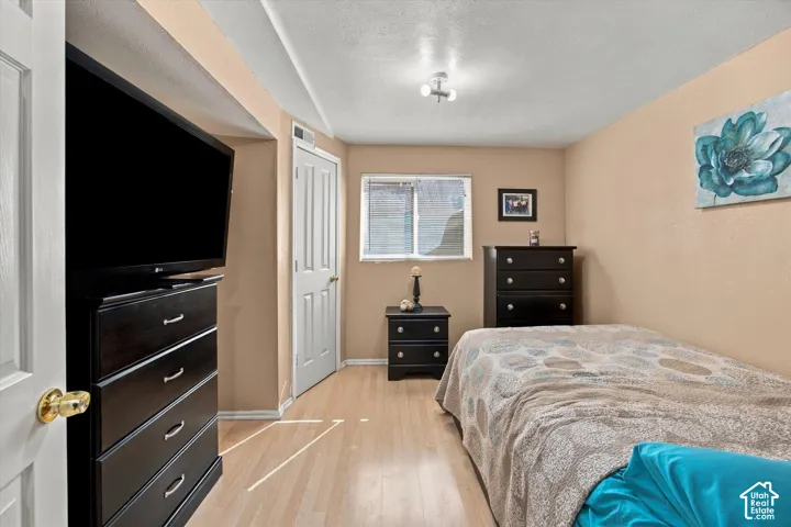 Recessed window with blinds, wood-finish flooring, and a flush-mount ceiling light