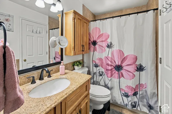Bathroom featuring a vanity with a light-toned countertop, an undermount sink, and a dark-toned faucet