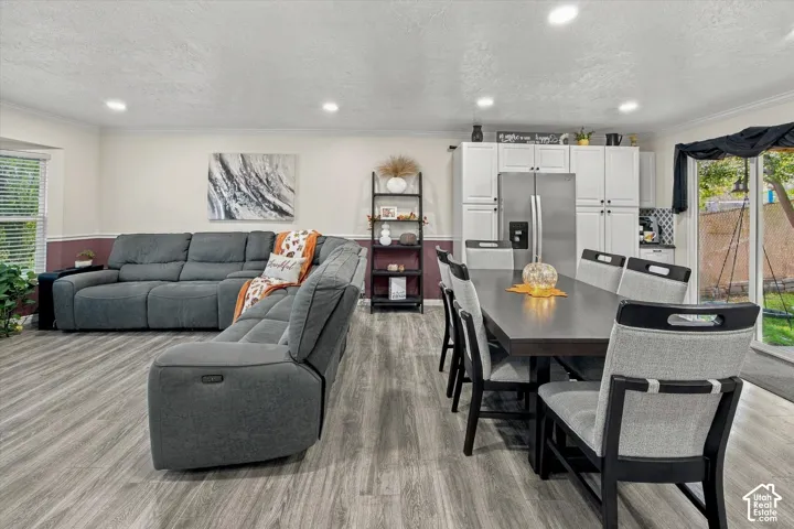 Open-concept living area featuring wood-finish flooring, recessed lighting, and a sliding glass door providing outdoor access