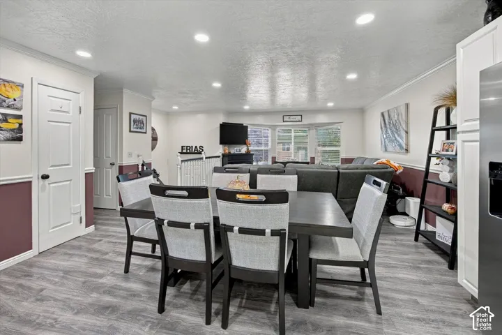 Recessed lighting throughout, wood-finish flooring, white paneled doors, and a bay window