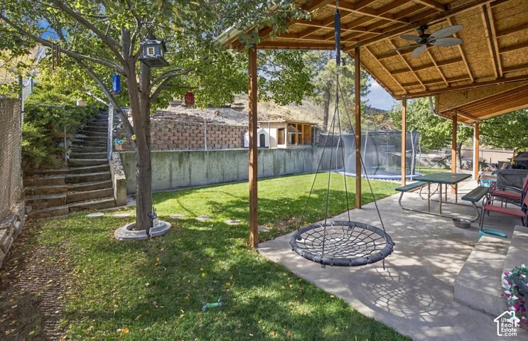 Covered patio with a ceiling fan, concrete flooring, and a flat roof structure