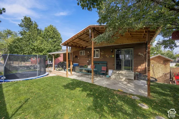 Expansive covered patio with a wood-finish ceiling, overlooking a manicured lawn