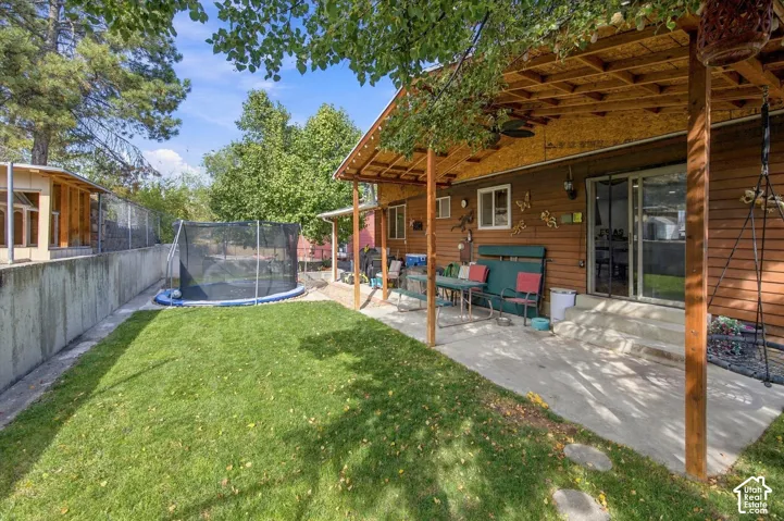 Expansive covered patio with exposed wood beams, concrete flooring, and direct outdoor access