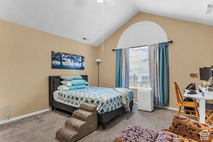 Vaulted ceiling, arched window accent, and neutral wall paint