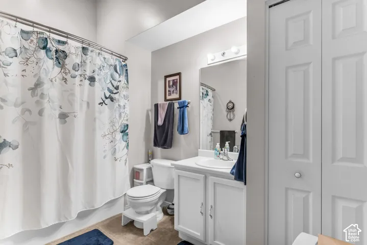 White vanity with a built-in sink, wall-mounted mirror, and overhead lighting