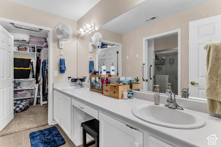Dual vanity with white cabinetry, integrated sinks, a wide mirror, and vanity lighting