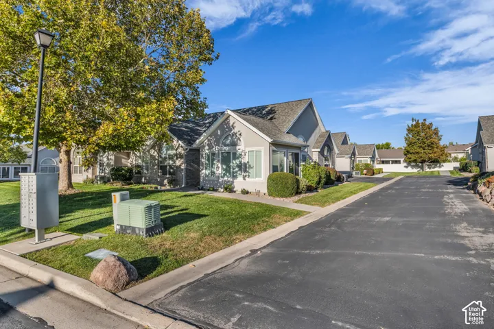 Manicured lawn with mature trees and a paved street