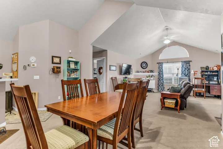 Vaulted ceilings with a ceiling fan, an arched window, and carpeted flooring