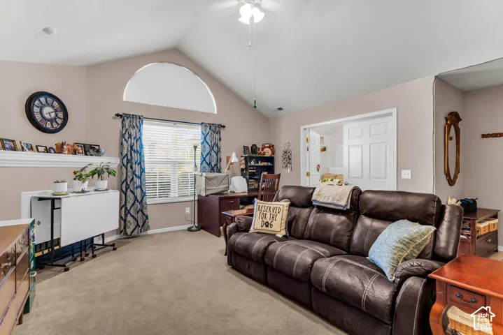 Vaulted ceiling with ceiling fan, arched window, and a rectangular window with blinds