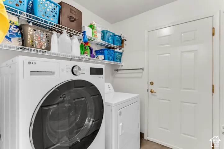 Laundry area featuring a front-loading washing machine, a dryer, and white wire shelving