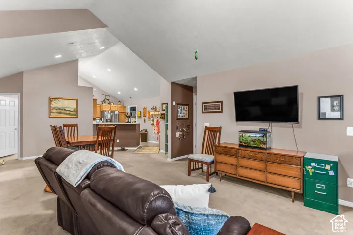Vaulted ceiling, recessed lighting, and warm neutral wall tones