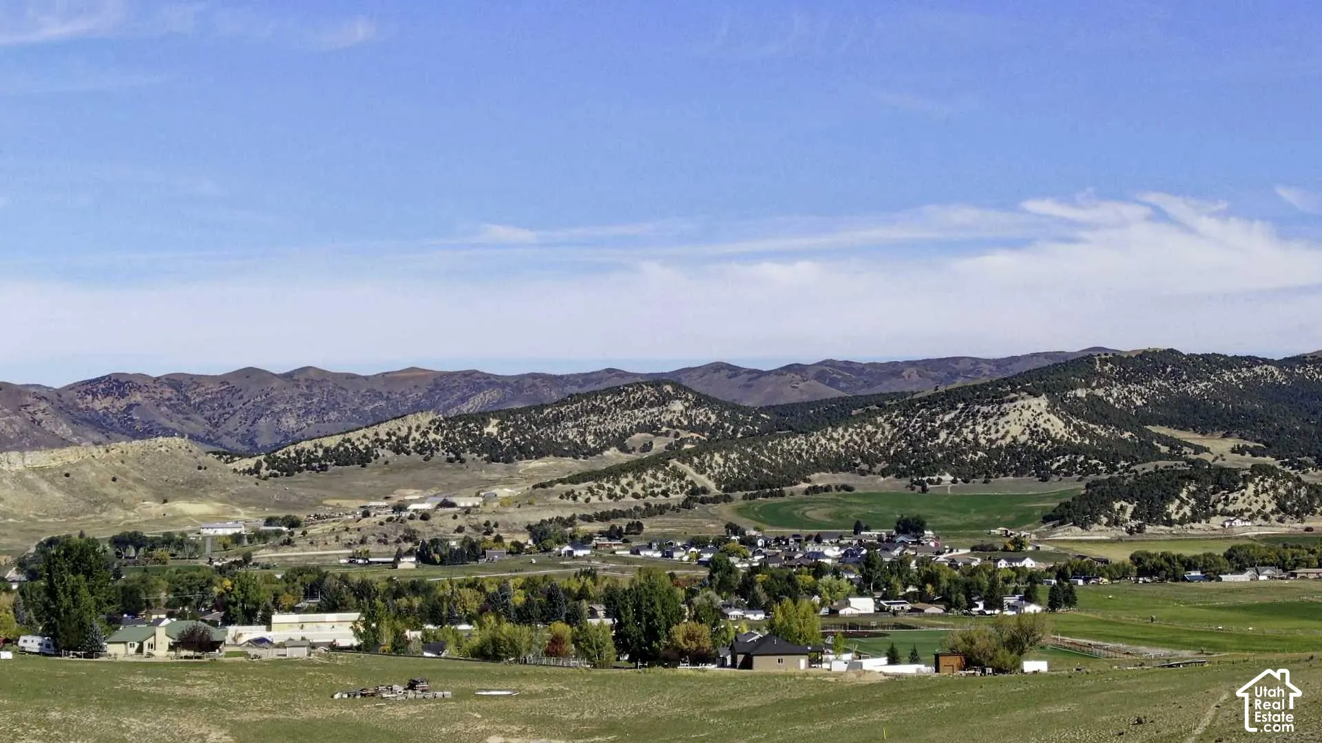 Expansive landscape featuring distant mountains, a valley, and a town