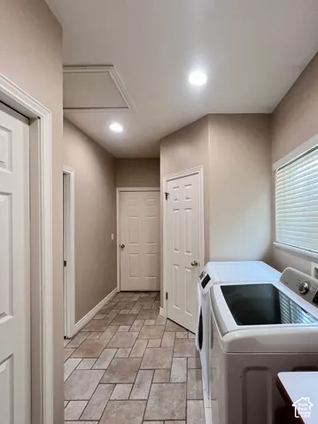 Recessed lighting illuminates the space, featuring a window with horizontal blinds and a tile floor with a geometric pattern