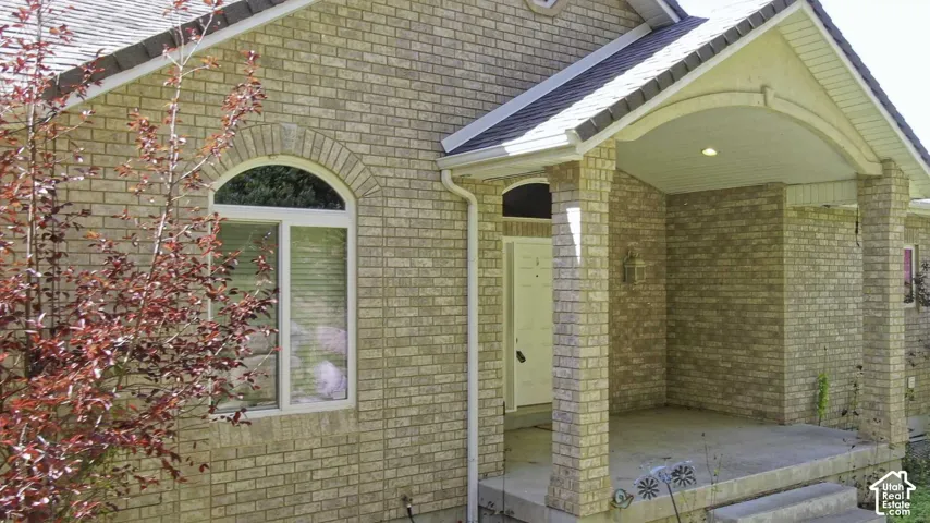 Brick exterior with arched window, covered entry, and traditional columns