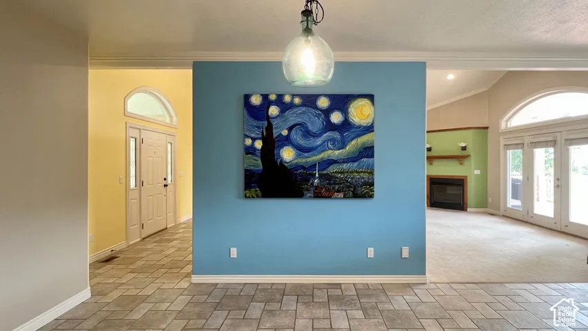 Tiled flooring, vaulted ceilings, arched doorways, a fireplace with a mantel, and French doors