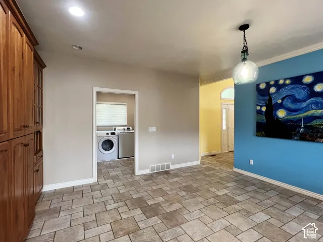 Tile flooring, recessed lighting, wood-finish cabinetry, laundry room access, and decorative wall molding
