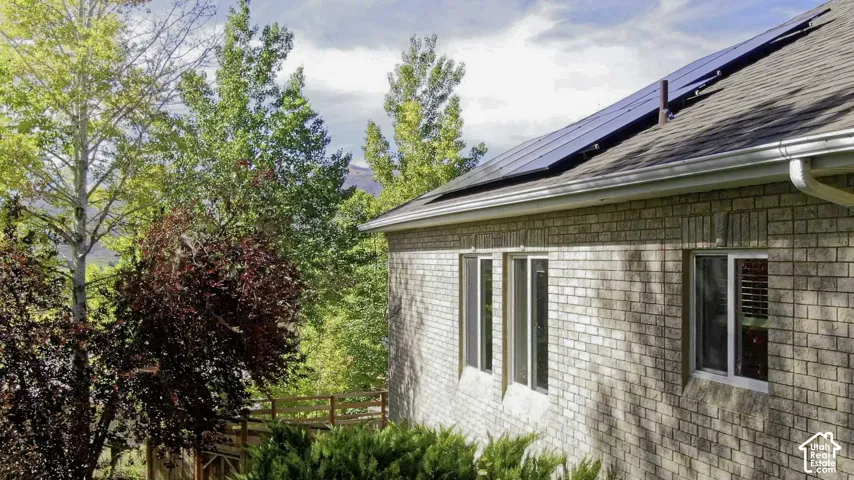 Brick exterior with multiple windows, solar panels, and a gabled roof