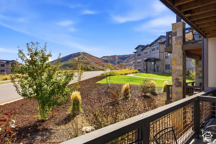 Private balcony with metal railing, stone column, and wood-paneled ceiling