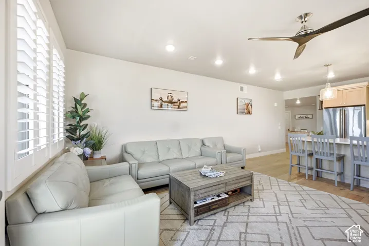 Recessed lighting and a modern ceiling fan illuminate the expansive open-concept living space