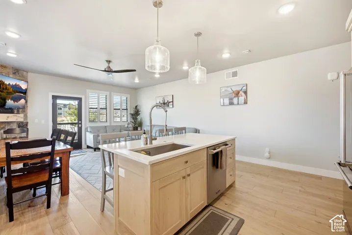 Open-concept living space featuring wood-finish flooring, recessed lighting, and a ceiling fan