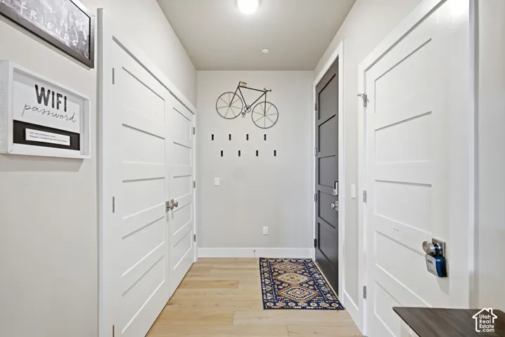 Light wood-finish flooring, white walls, and white four-panel doors