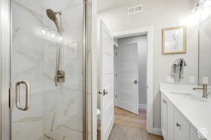 Glass-enclosed shower with a handheld showerhead and wall-mounted tile