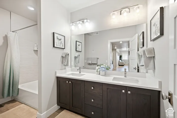 Double vanity with dark wood-finish cabinetry, white countertops, and integrated sinks