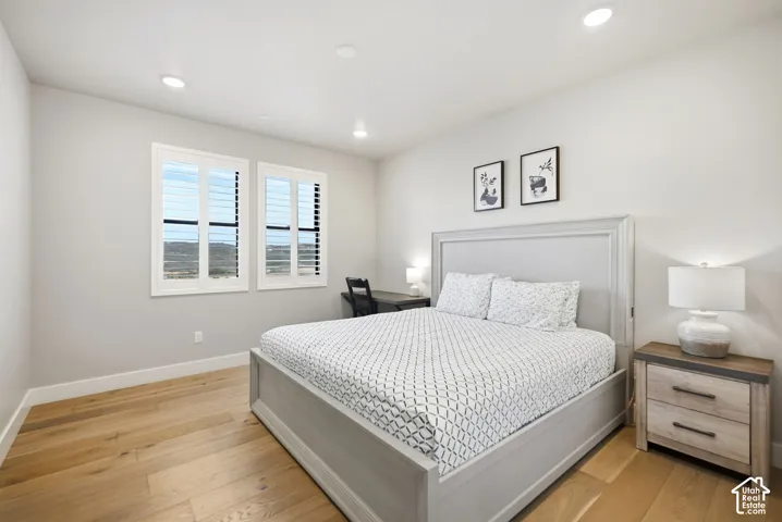 Recessed ceiling lighting, wood-finish flooring, plantation shutters, and a streamlined headboard