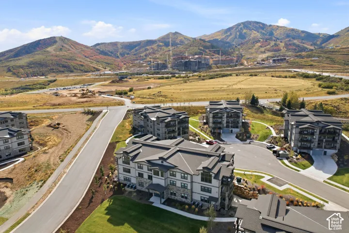 Multi-story residential buildings with stone and siding exteriors, featuring gabled roofs and private balconies