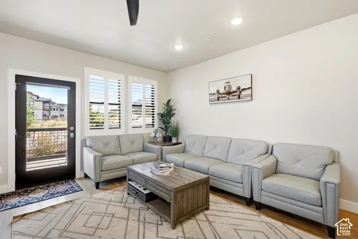 Recessed ceiling lighting, wood-finish flooring, white plantation shutters, and a full-light entry door