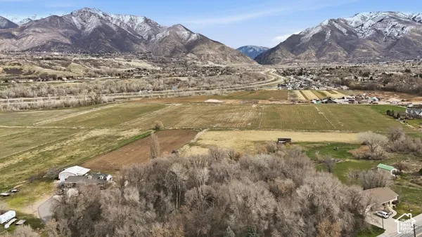 Expansive land parcel featuring cultivated fields, natural terrain, and distant mountain ranges with snow-capped peaks