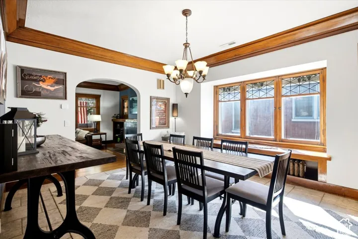 Coffer-style wood trim, arched doorway, and built-in window seating with leaded glass transom windows