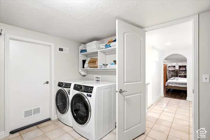 Laundry area with tile flooring and built-in shelving