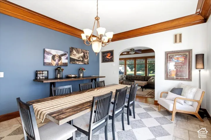 Archway entry to a separate space, wood-finish ceiling trim, and a tile floor