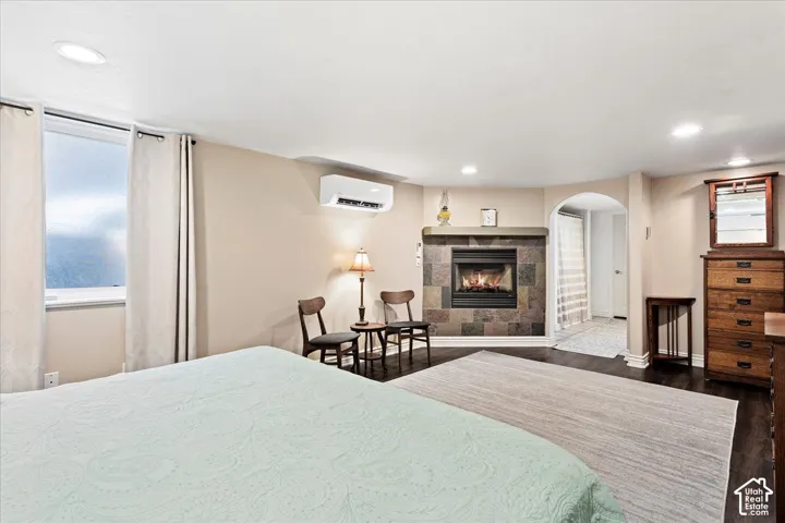Recessed lighting illuminates the room, featuring wood-finish flooring and an arched doorway