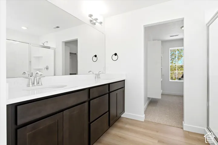 Dual vanity with undermount sinks, stone countertop, and wood-finish cabinetry