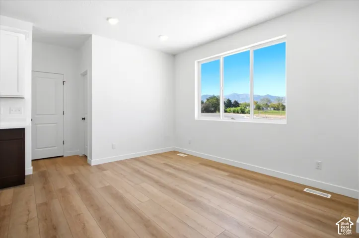 Recessed lighting illuminates the open area with wood-finish flooring