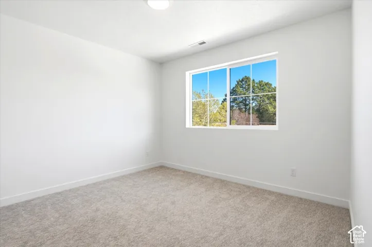 Neutral wall color, wall-to-wall carpeting, recessed ceiling lighting, and a large window